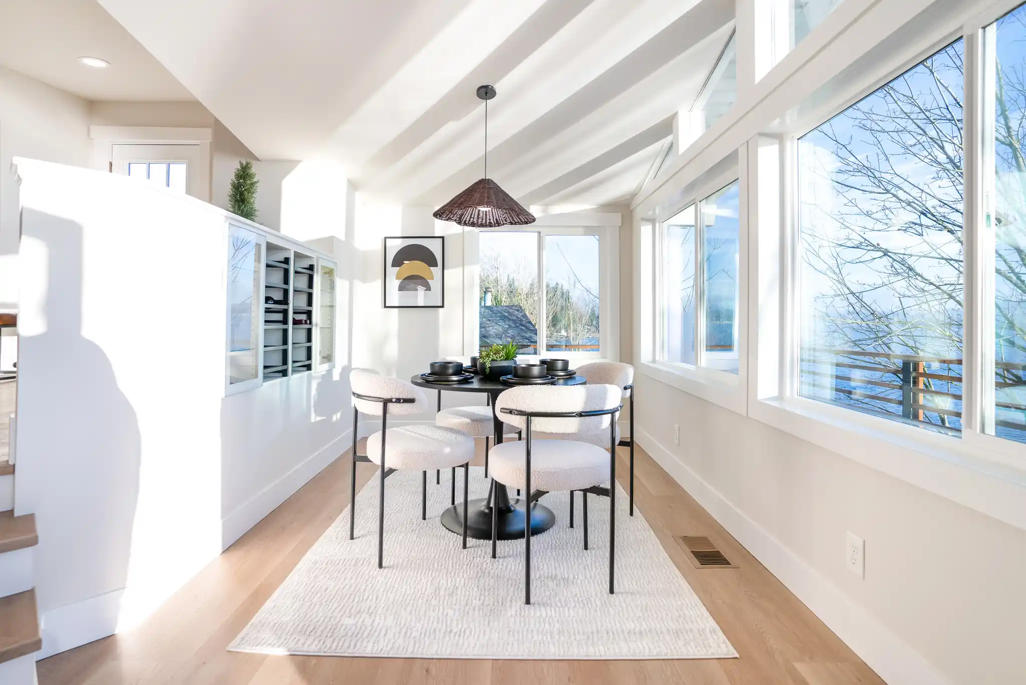 bright staged Seattle craftsman living room with refinished oak floors, fresh white walls, large windows, and subtle Puget Sound-inspired decor