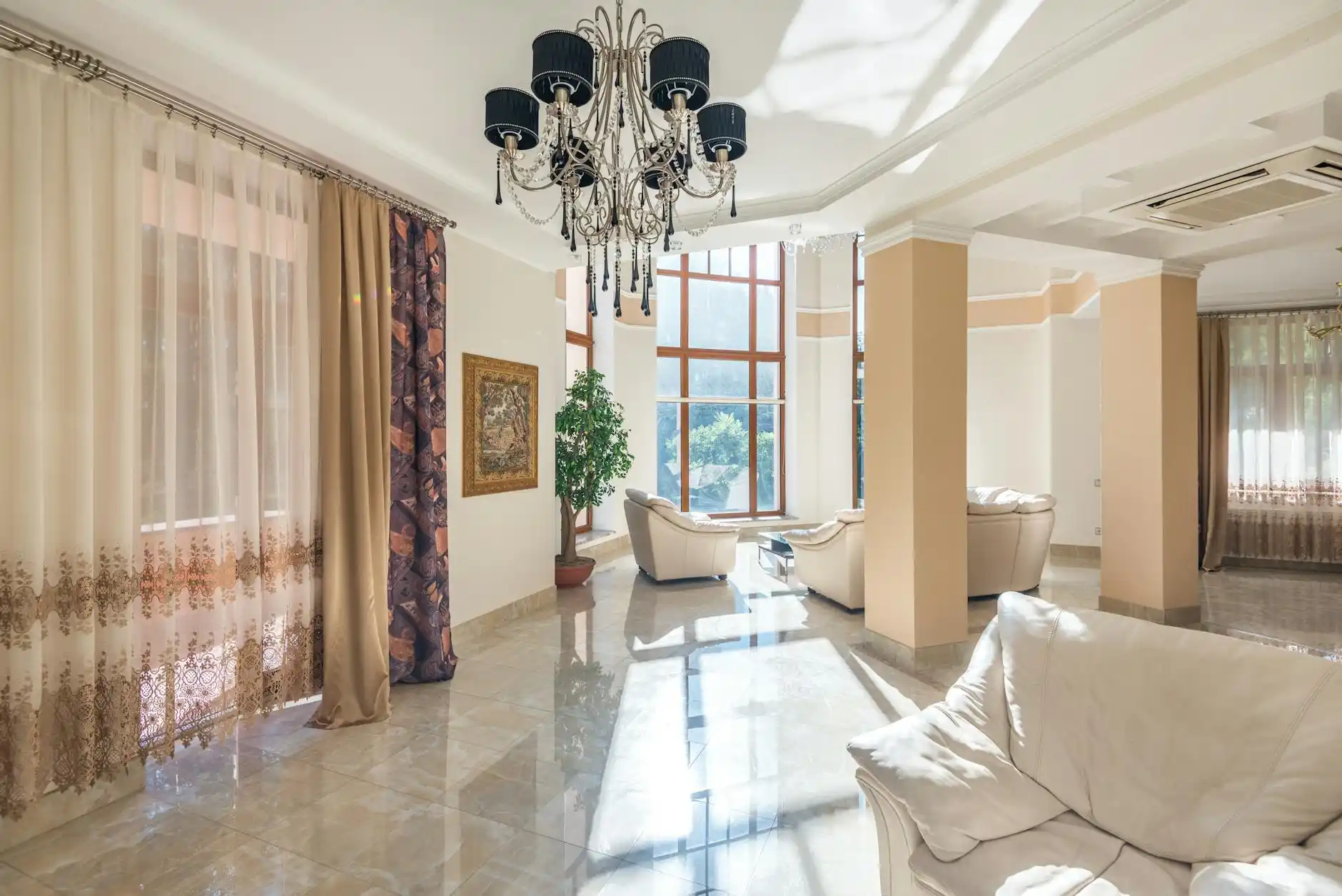 elegant completed custom home living room with wide oak floors, floor-to-ceiling fireplace, built-in shelving, oversized windows, and soft natural afternoon light