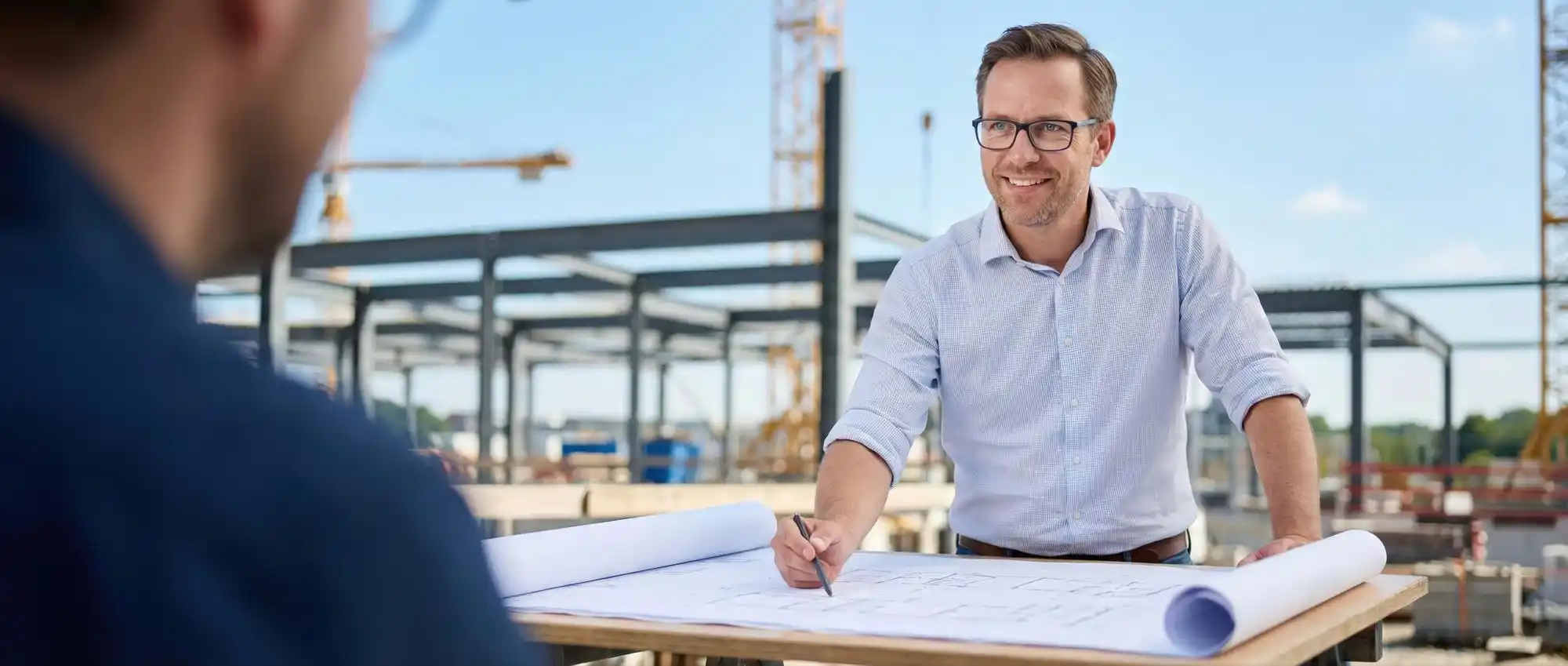 luxury home construction site with crane placing steel beams, architect reviewing blueprints, and partially completed modern hillside estate at sunrise