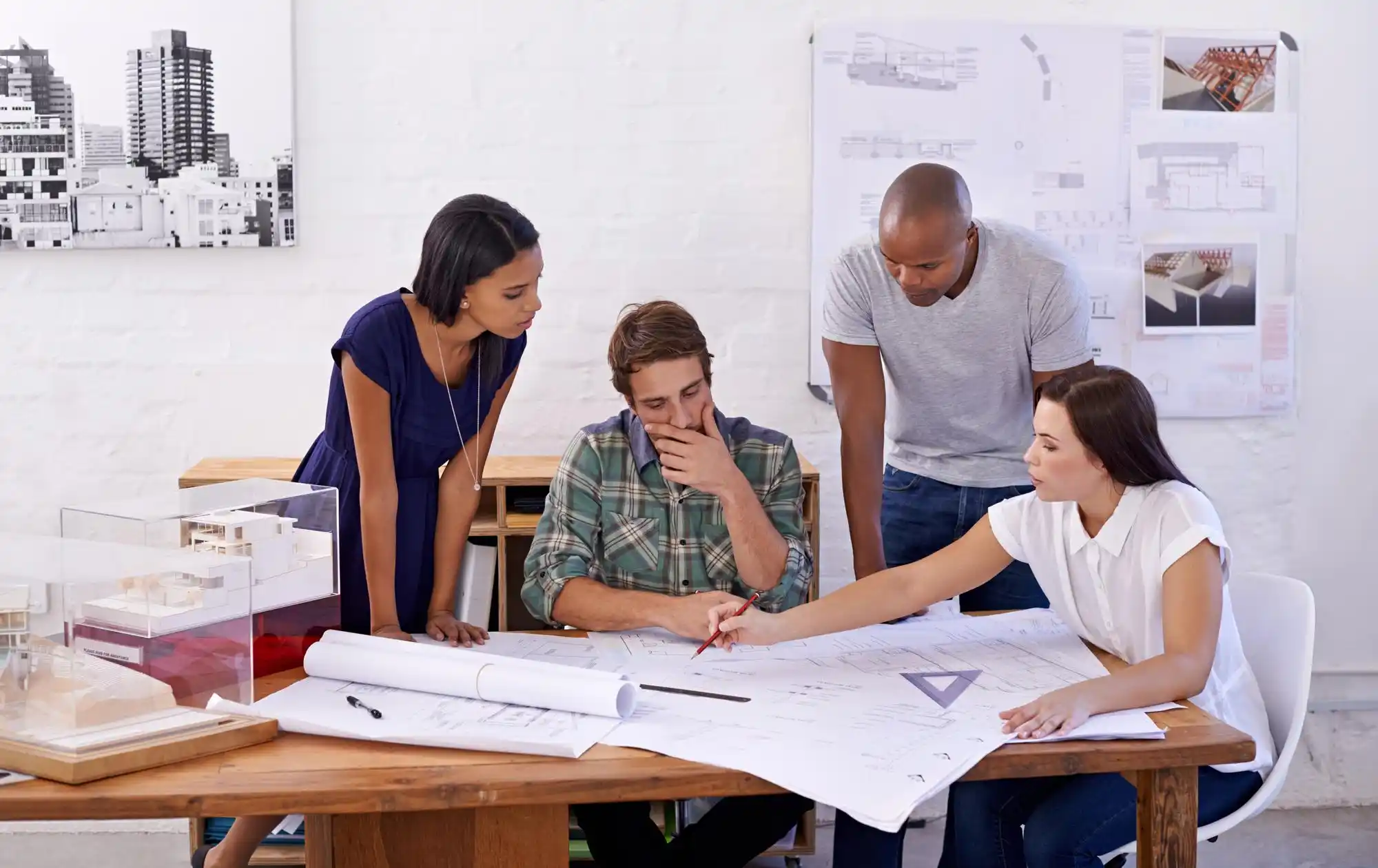 Project timeline board in a Seattle real estate office showing renovation tasks, staging dates, and listing launch calendar with contractor and seller discussing schedule
