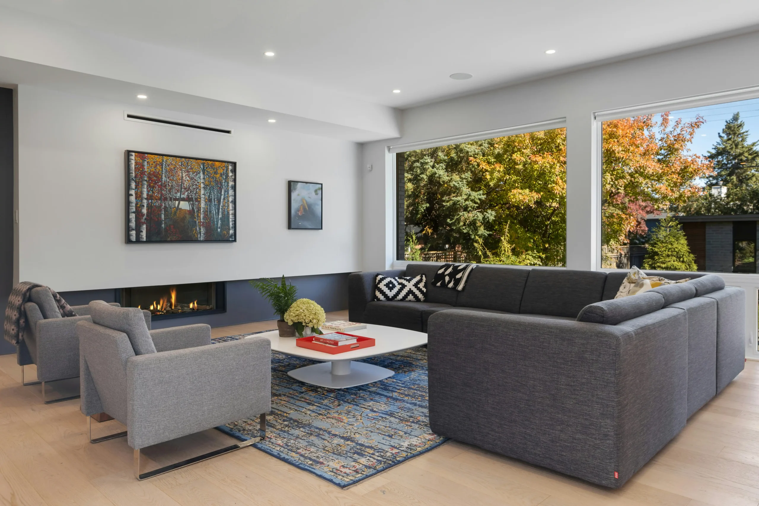 Seattle living room staged after renovation with neutral furnishings, fireplace, large windows, soft natural light, and a sold-ready polished finish