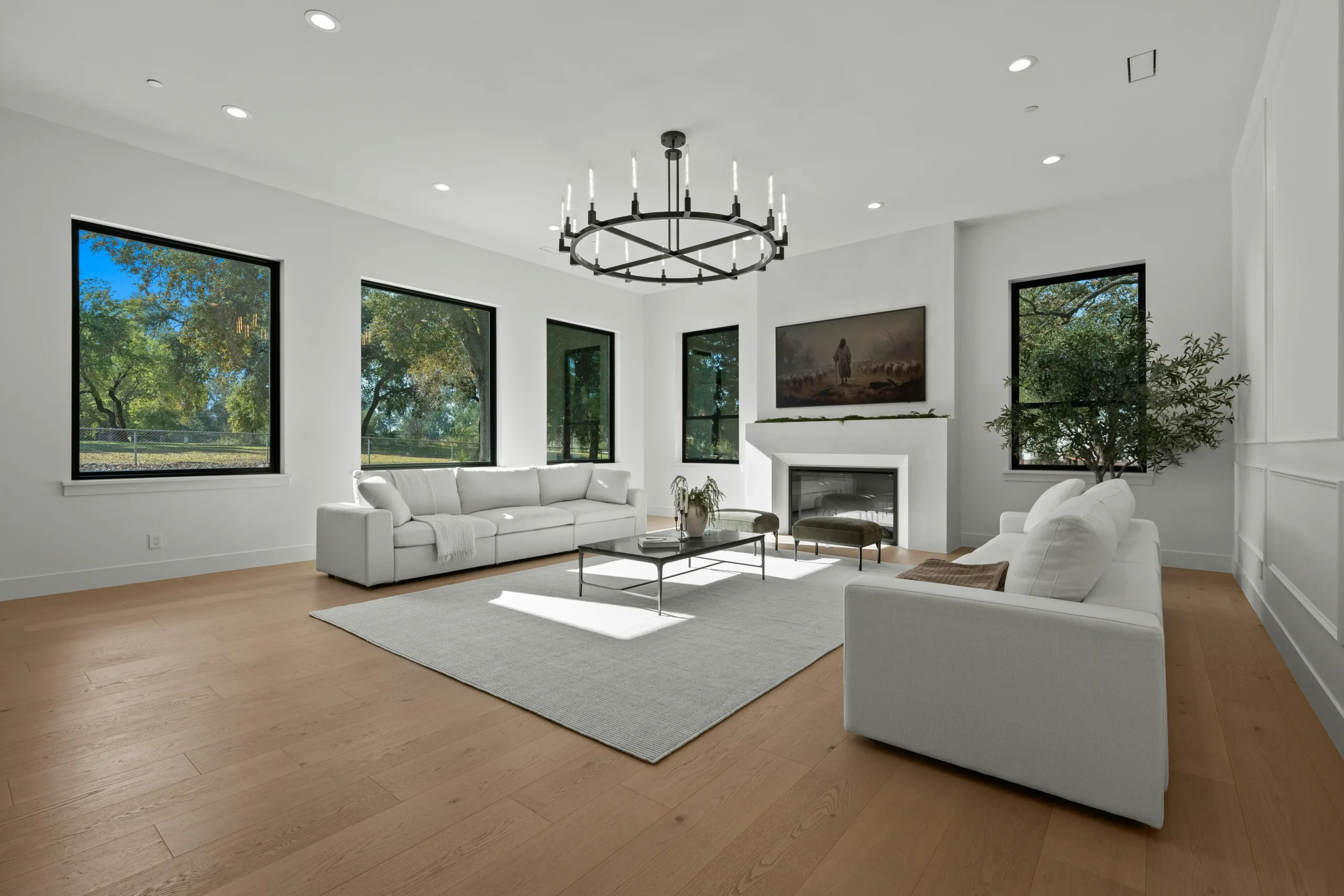 staged Seattle living room with refinished hardwood floors, soft gray walls, large windows, minimalist furniture, and natural Pacific Northwest daylight