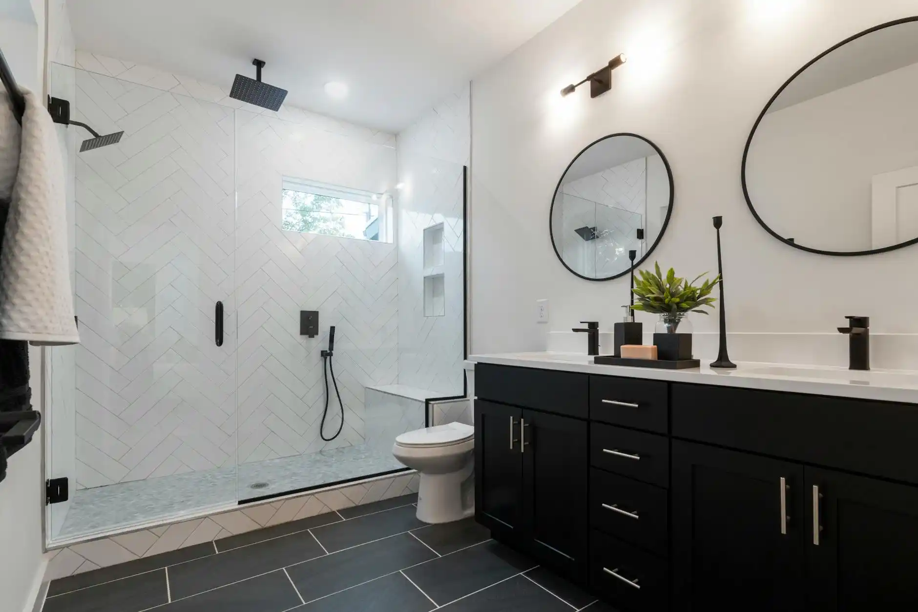contractor reviewing bathroom remodel estimate with homeowners at a kitchen table, sample boards showing porcelain tile, quartz vanity top, matte black fixtures, and detailed li...