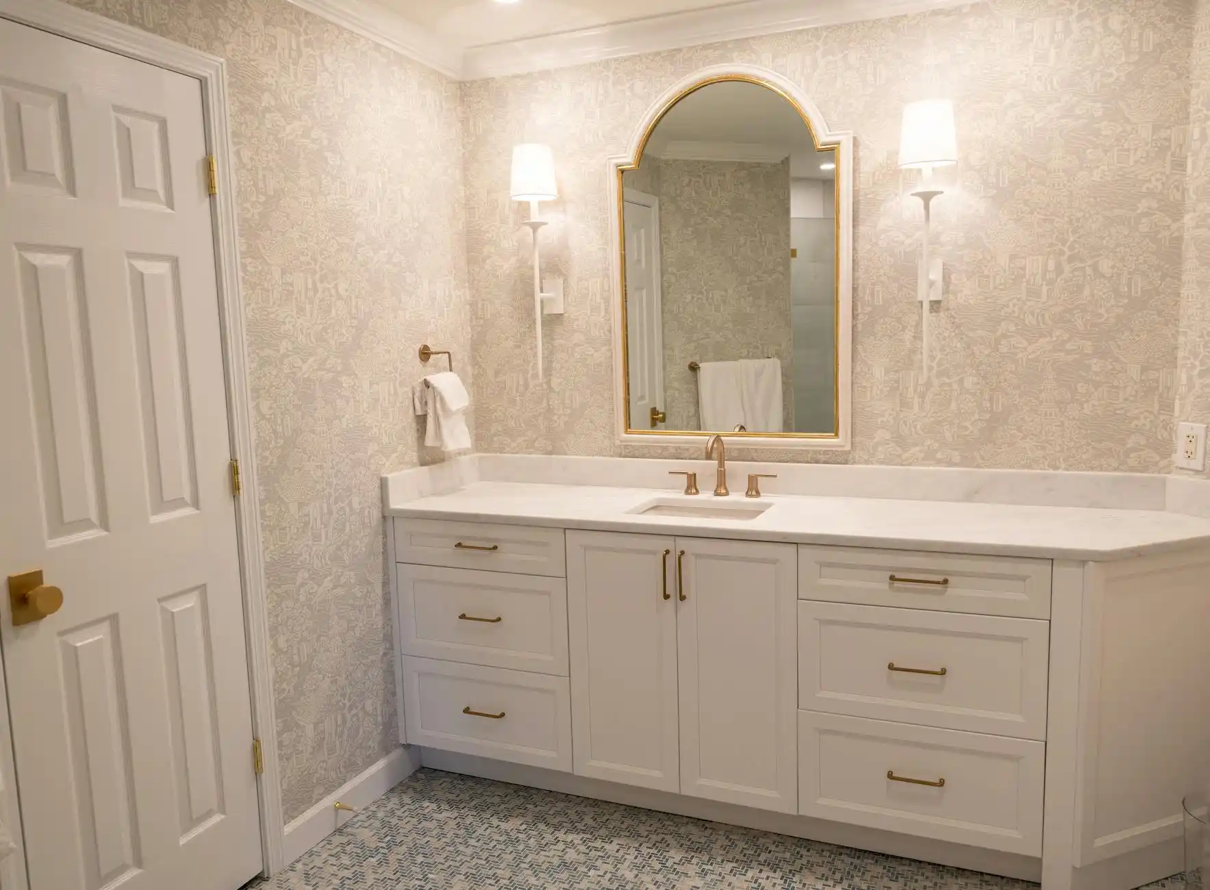 finished bathroom with practical upgrades highlighted, including quiet ceiling exhaust fan, well-lit mirror sconces, durable porcelain tile shower, and shaker vanity with organi...