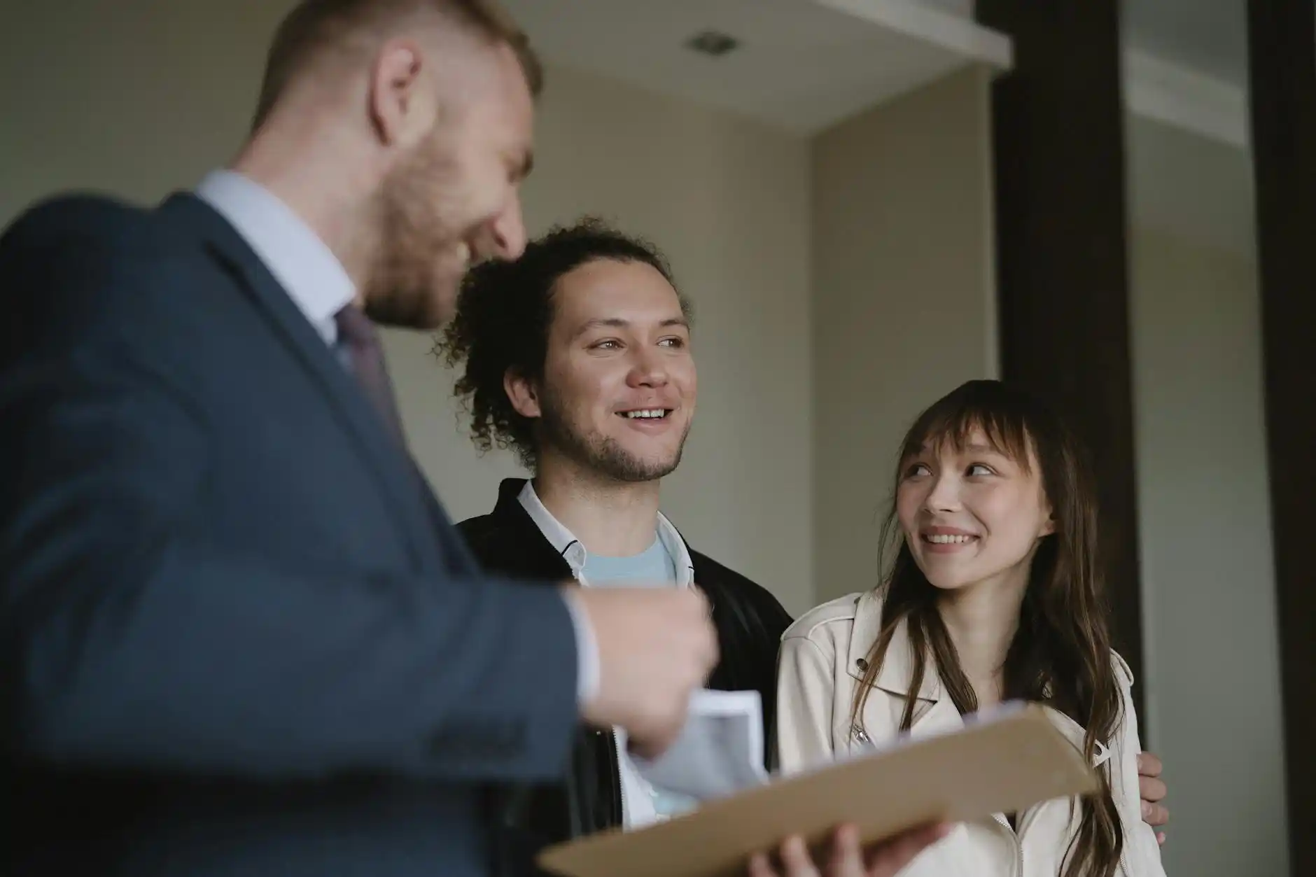 happy couple touring two options, one elegant custom home under construction with exposed beams and one furnished production model home in a new community
