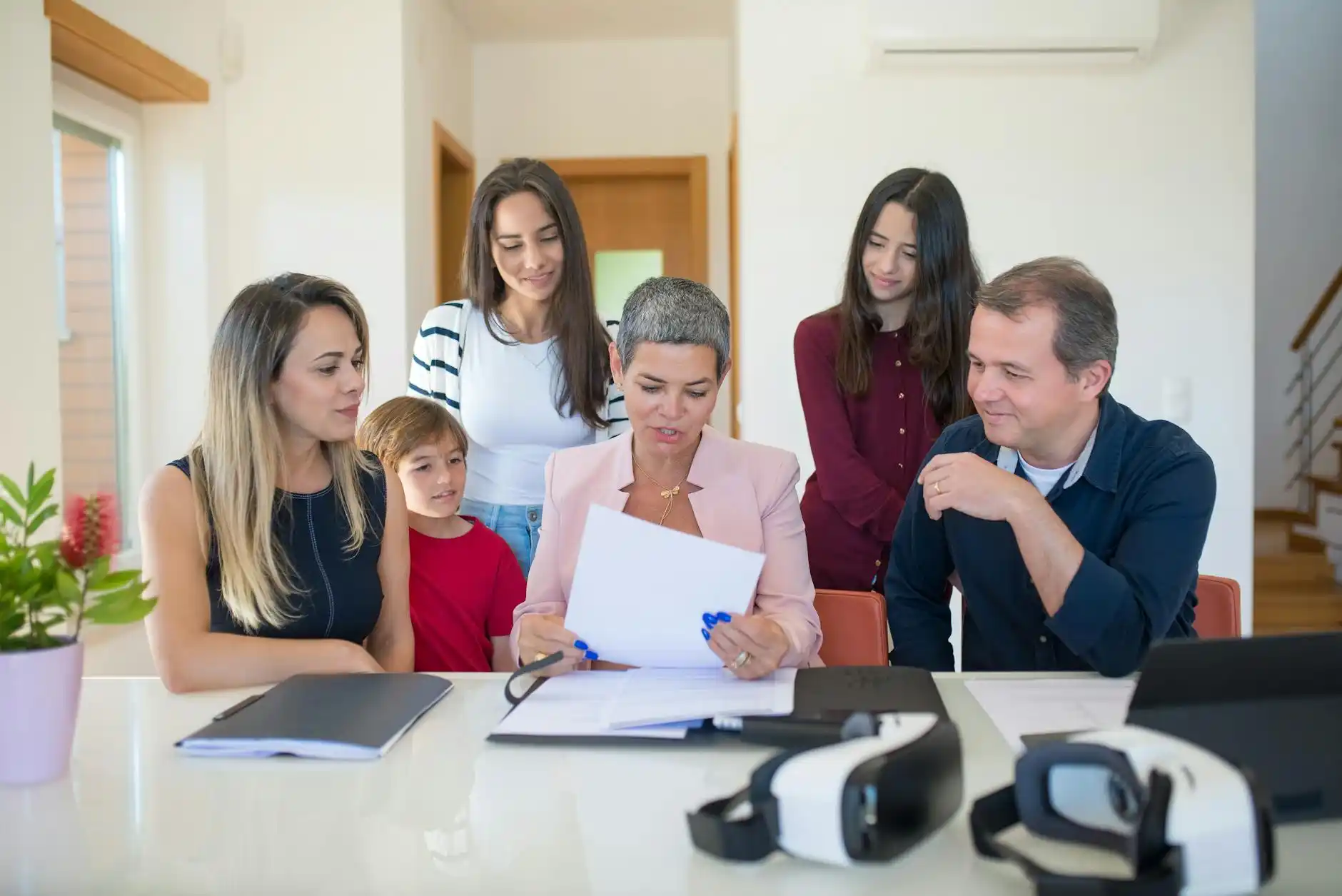 real estate agent and home seller in a bright Seattle living room reviewing a listing prep checklist, contractor bid, and staged property photos