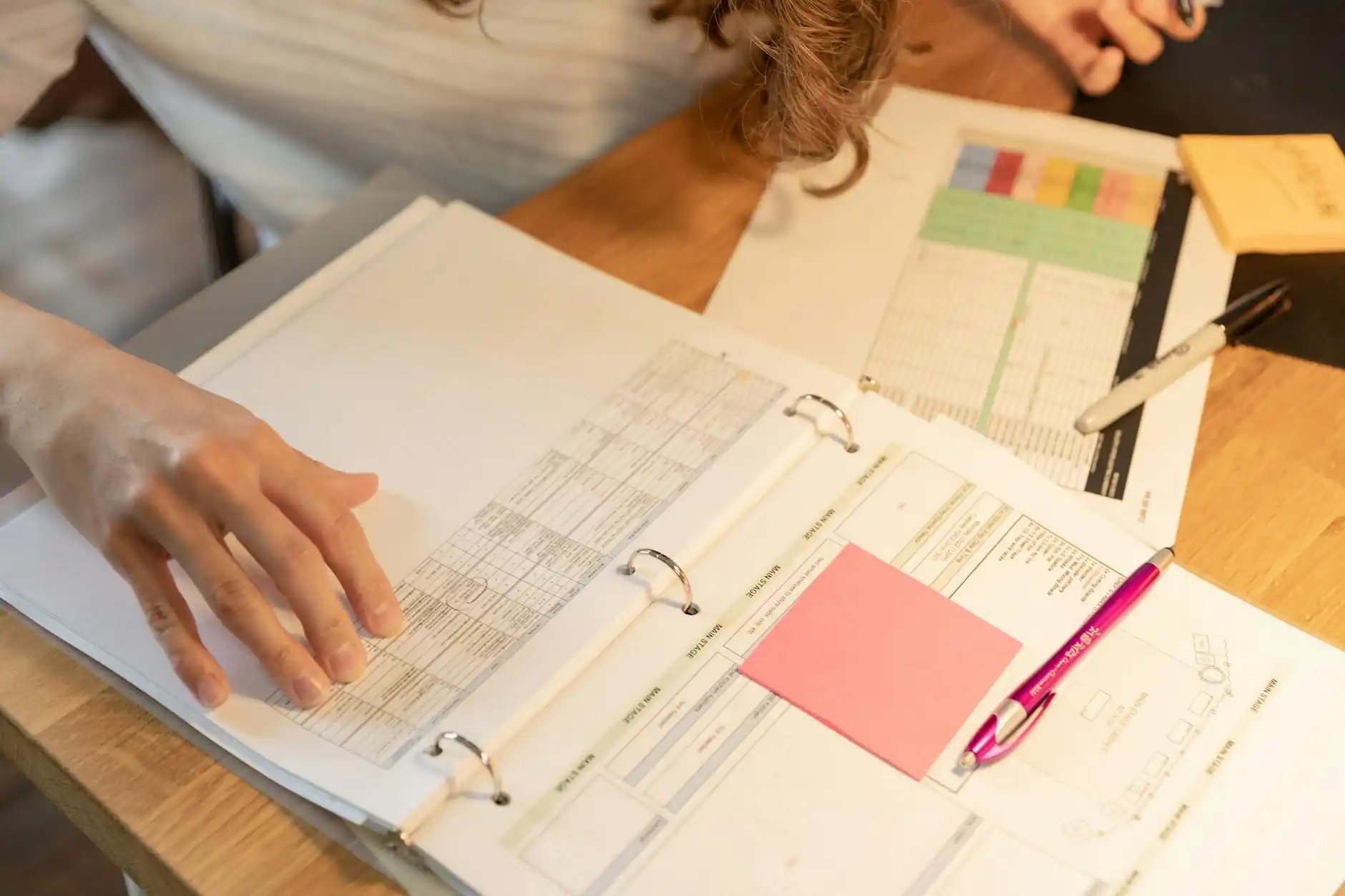 organized renovation project folder on a desk with labeled tabs for estimates, escrow instructions, seller approvals, before-and-after photos, and contractor invoices