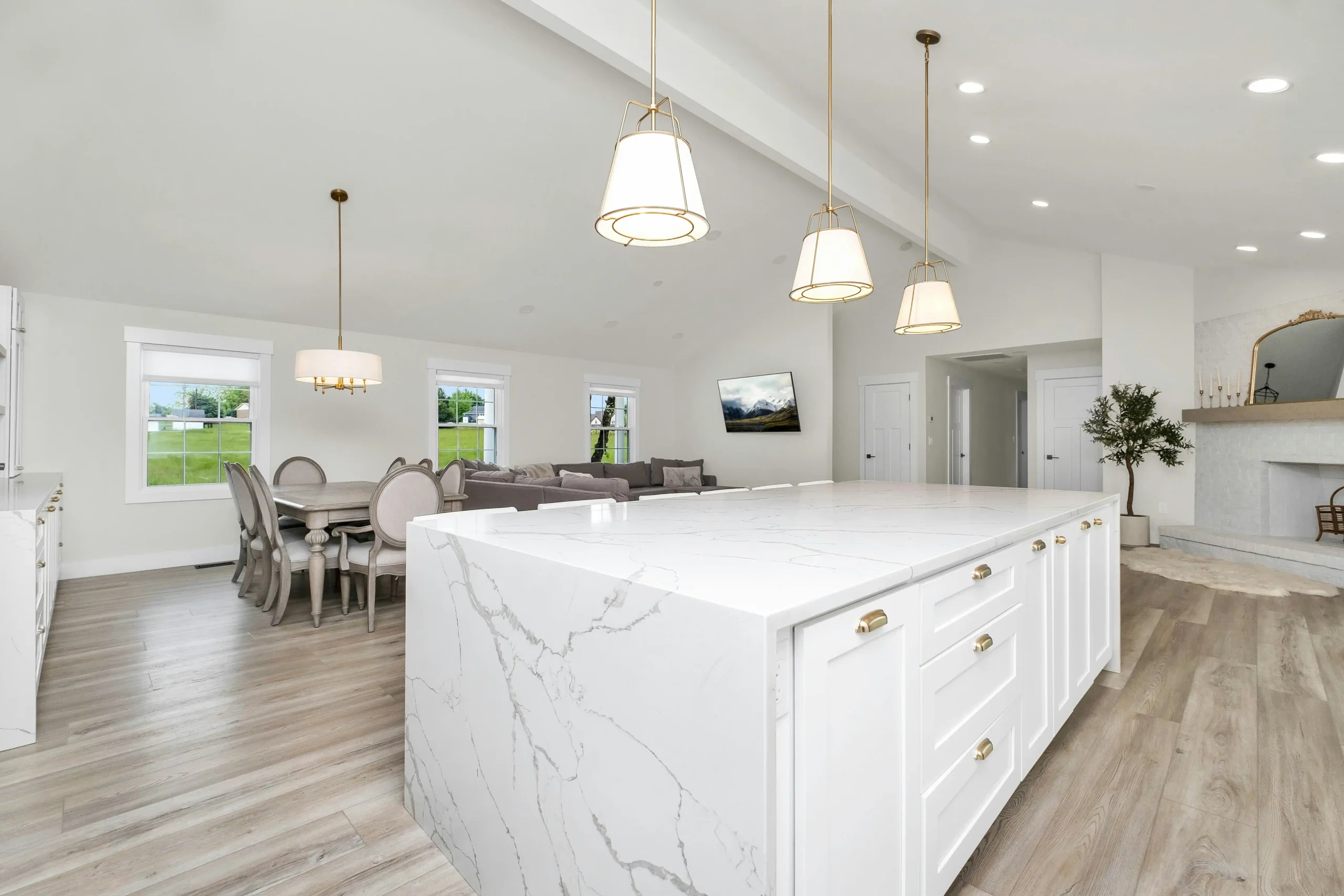 contractor and homeowner reviewing detailed renovation estimate at a kitchen island with flooring samples, cabinet door styles, and printed project timeline