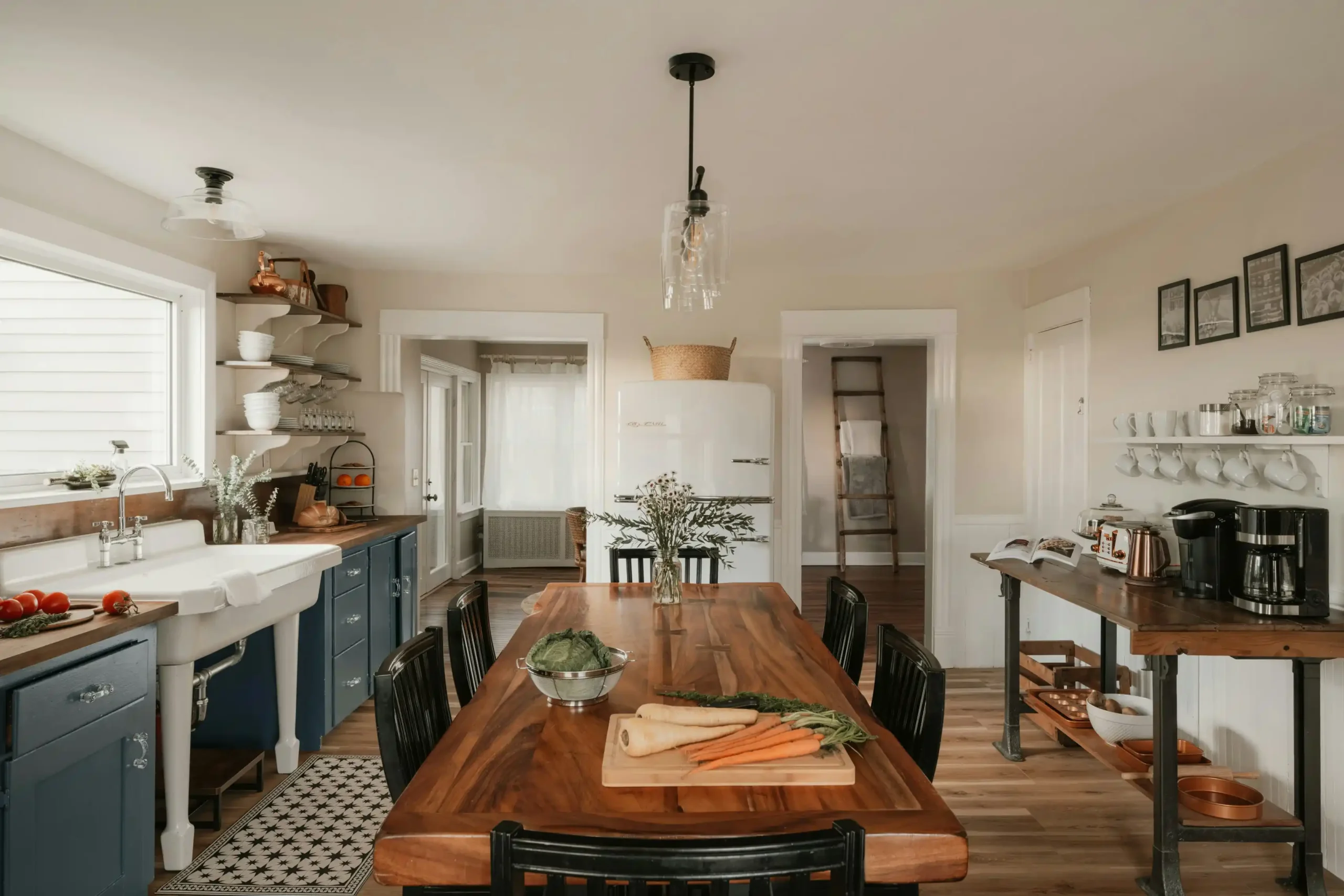 organized temporary kitchen setup in a dining room with microwave, coffee station, mini fridge, paper plates, and labeled storage bins during a home renovation
