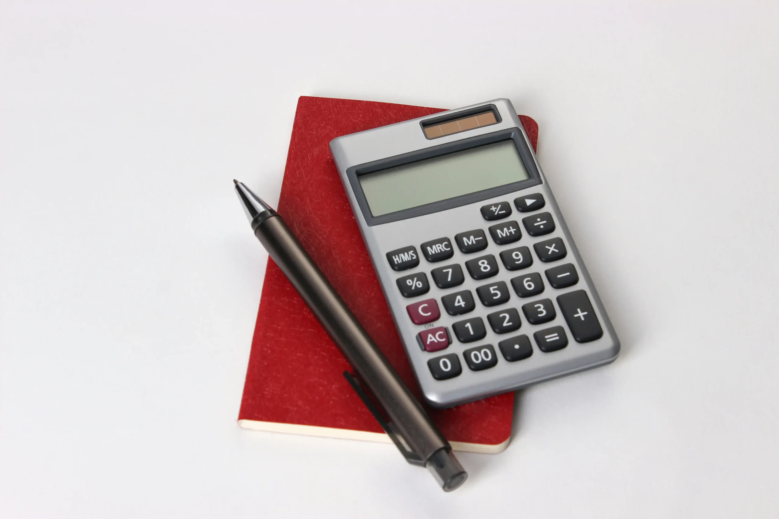 homeowner reviewing a contingency budget spreadsheet beside paint samples, stone slabs, and a calculator in a partially framed luxury home