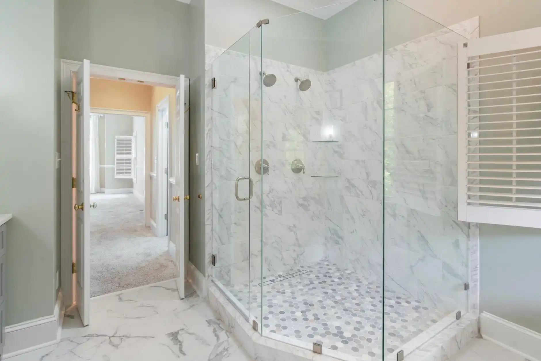 elegant primary bathroom inspiration board with warm wood vanity, matte black hardware, large-format porcelain tile, frameless glass shower, and layered lighting
