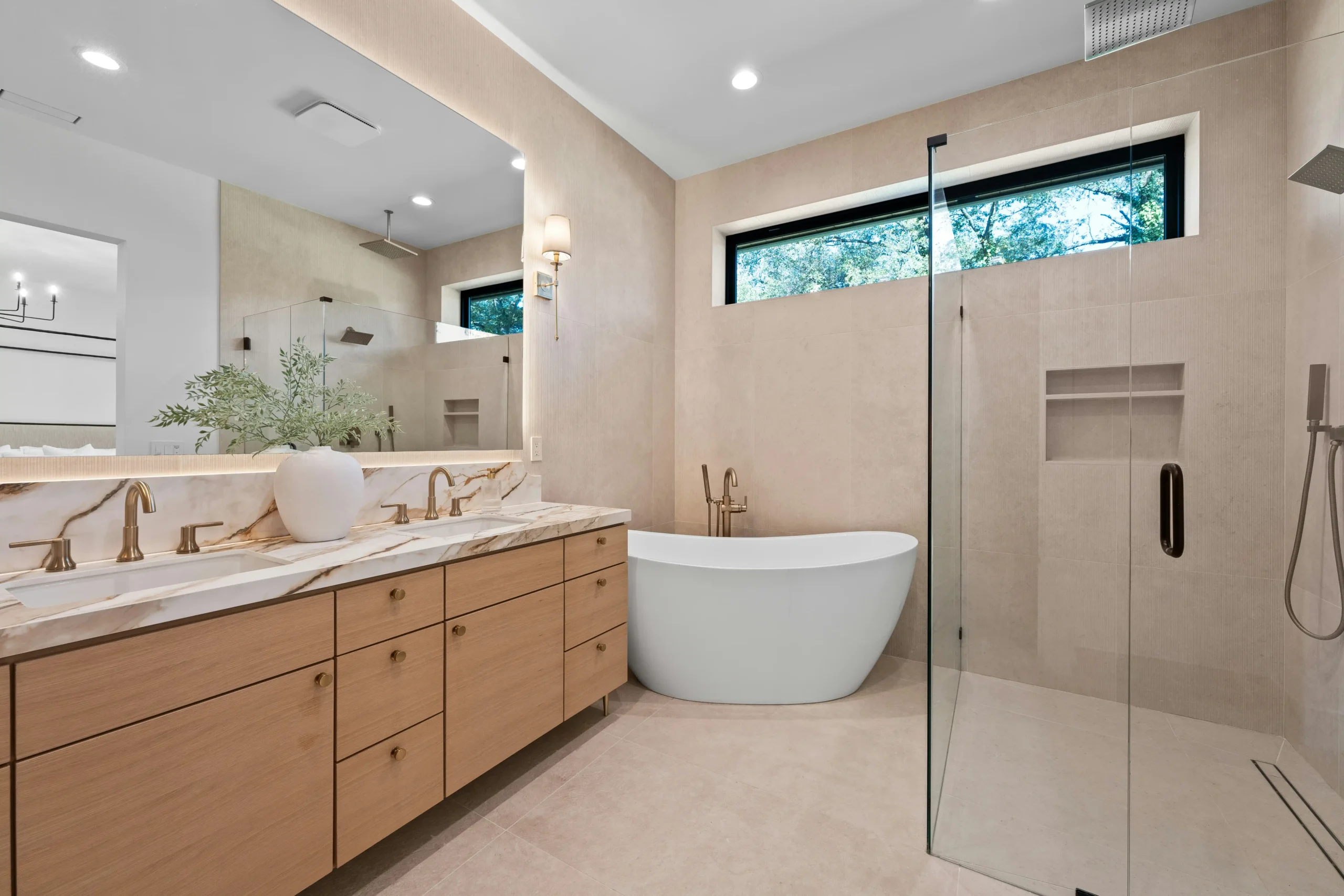 bright partially remodeled bathroom with exposed studs, stacked white subway tile on one wall, freestanding tub nearby, contractor tools neatly arranged, natural daylight throug...