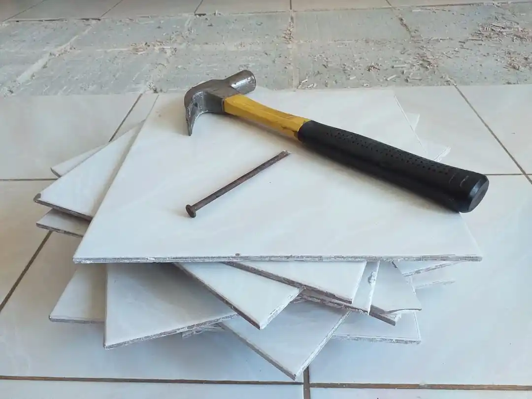 bright contemporary bathroom renovation in progress with removed vanity, exposed plumbing, stacked porcelain tile, brass fixtures laid out on protective floor covering