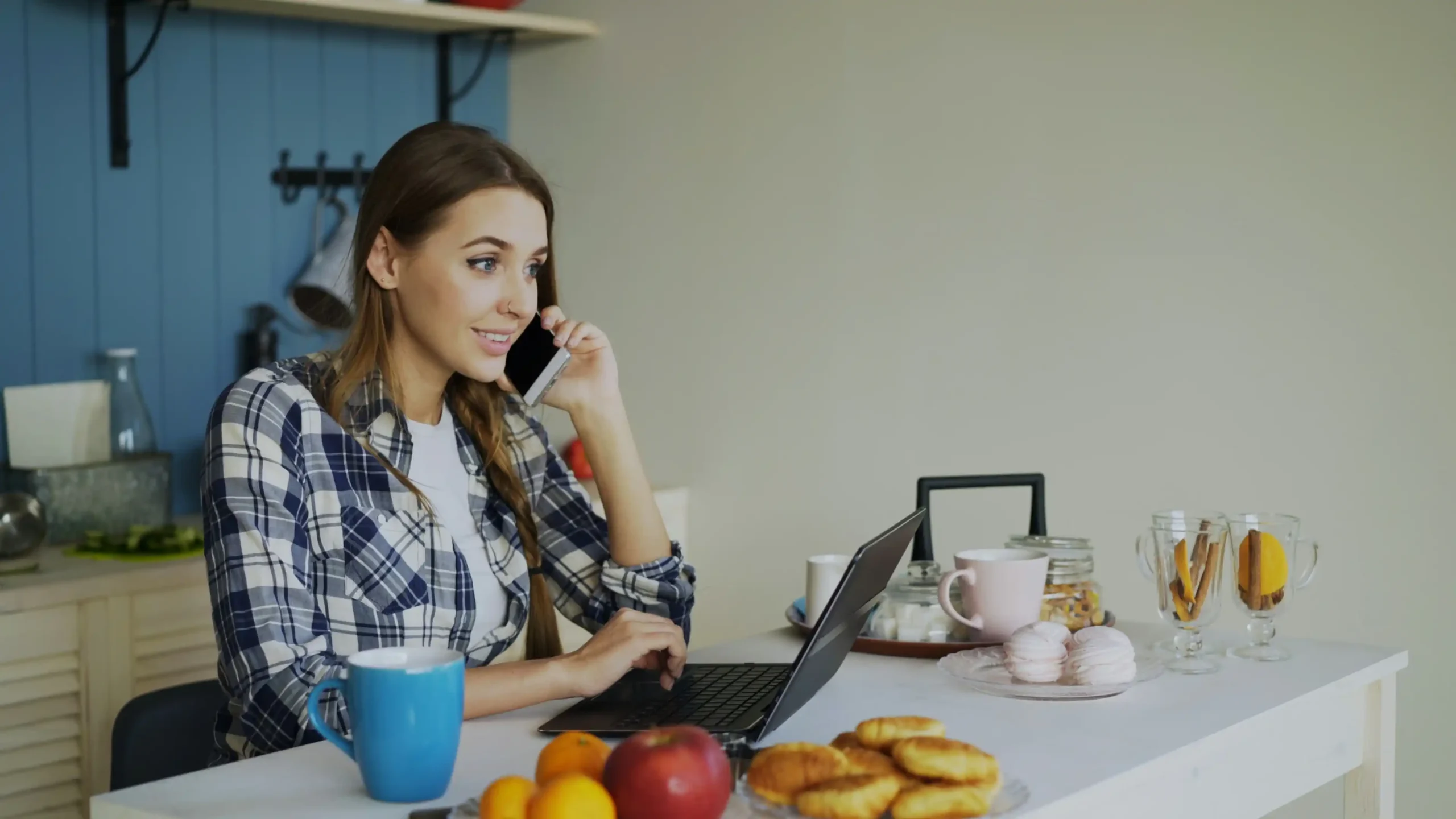 homeowner at a kitchen table reviewing bathroom contractor profiles on a laptop, notepad with quotes and checklists beside coffee cup, bright natural morning light, modern subur...
