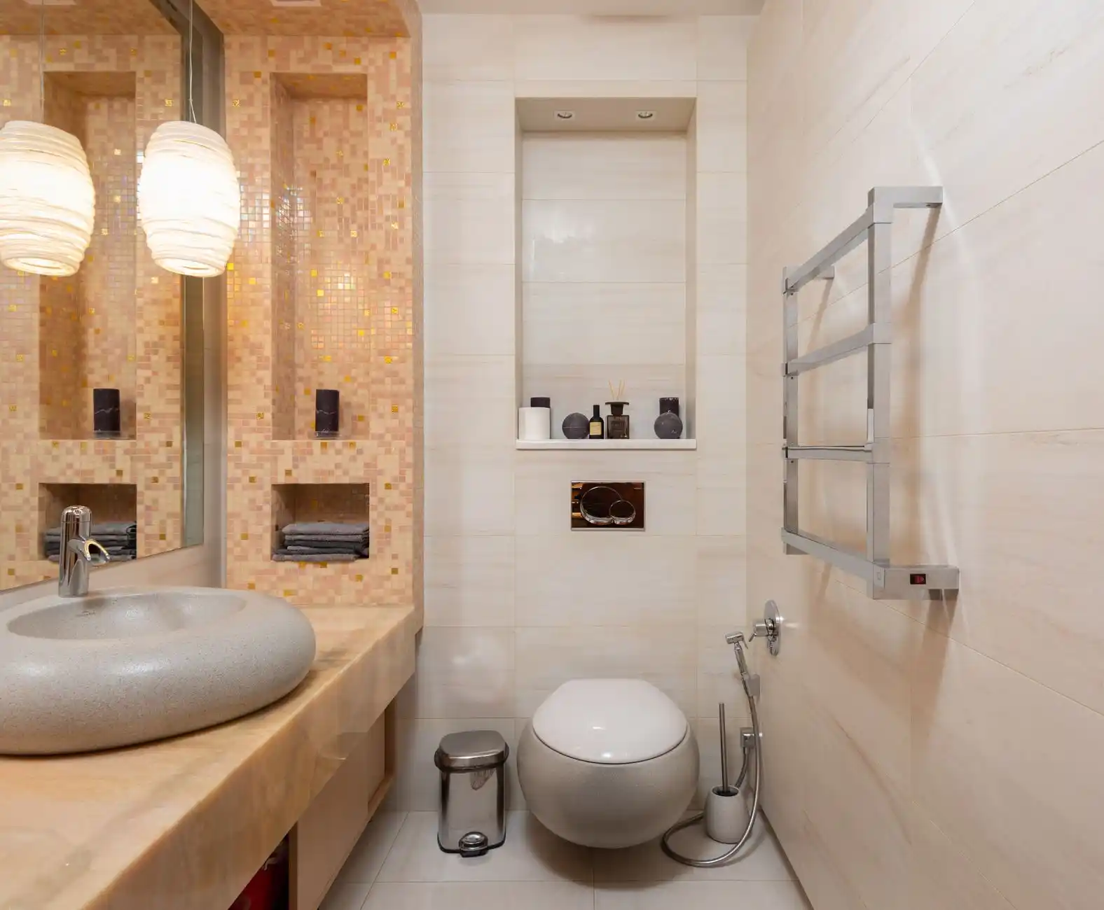 elegant small bathroom with curbless shower, wall-mounted toilet, floating white vanity, recessed niche, and matte black fixtures with warm layered lighting