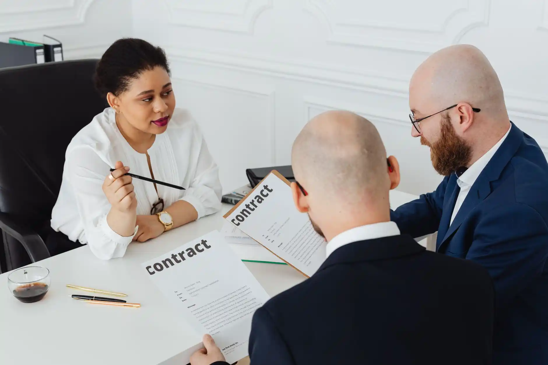 real estate attorney in a modern conference room highlighting clauses in a home construction contract, architectural rendering on screen, homeowner couple listening attentively