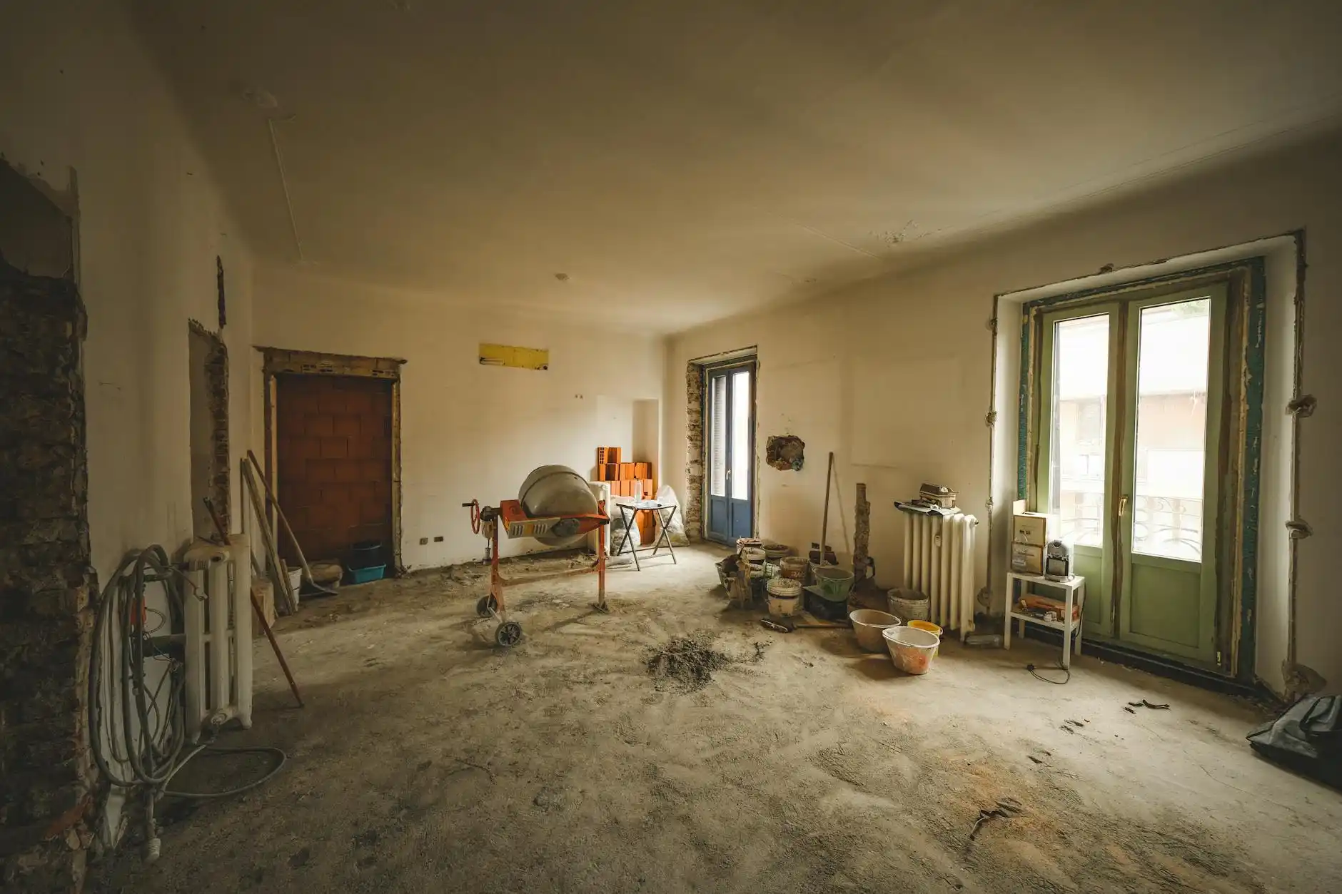 custom home interior under construction with marked-up plans, recessed lighting layout notes, and a builder explaining finish changes to homeowners in a partially completed livi...