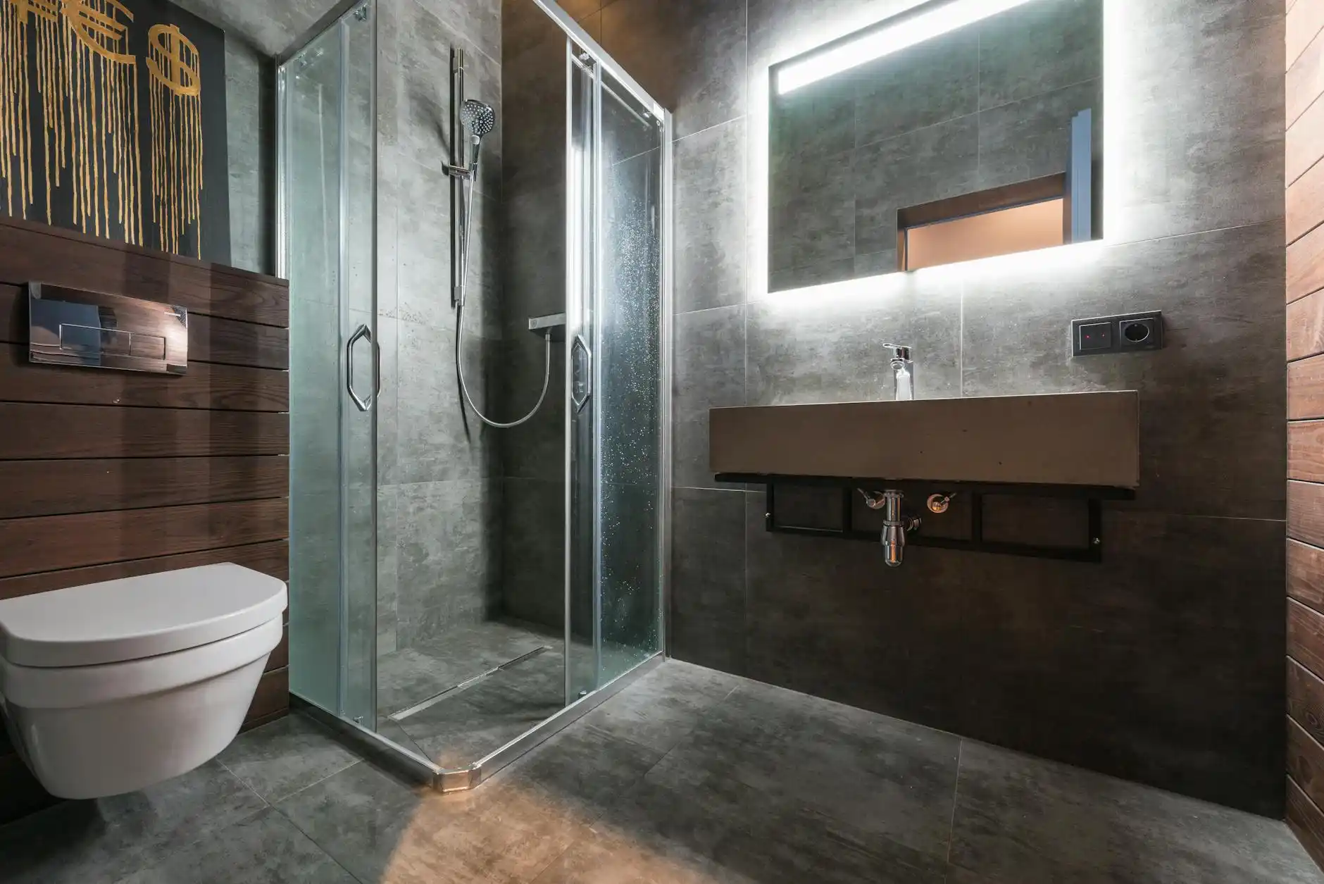 bright upscale bathroom remodel in progress with floating vanity samples, brushed brass fixtures, large-format porcelain tile boards, and a homeowner reviewing estimates at a ki...