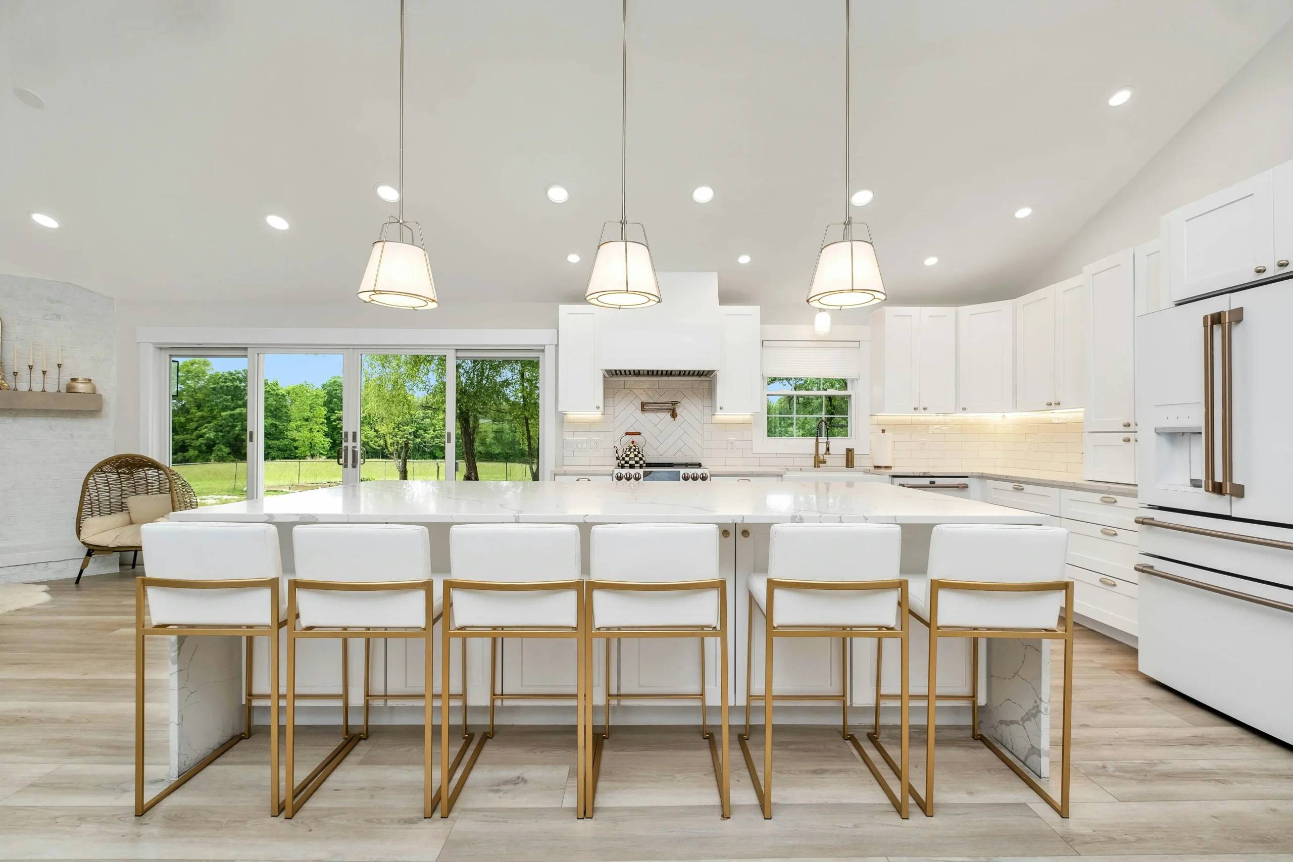 bright transitional kitchen renovation with shaker cabinets, quartz countertops, brass hardware, and large island in a suburban American home