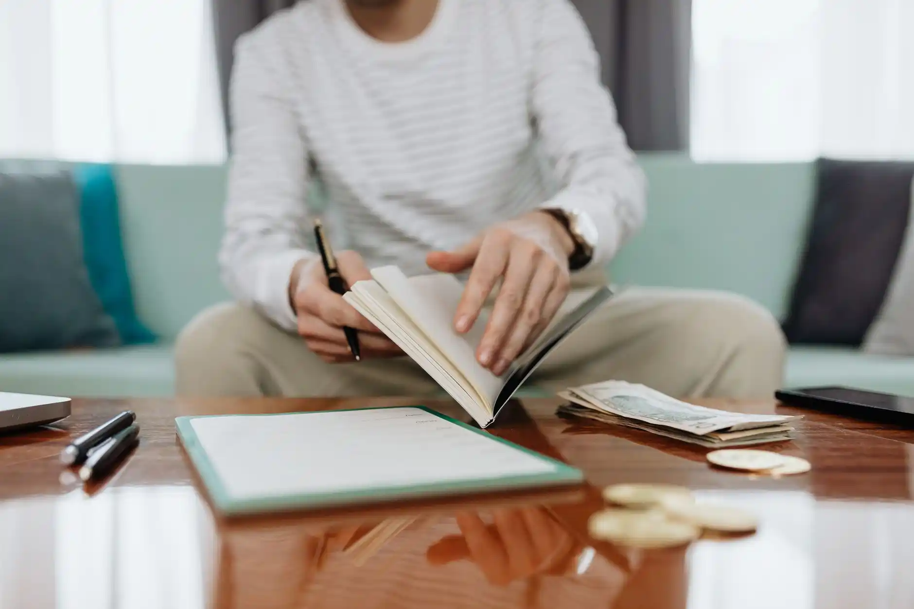 homebuyer reviewing renovation budget and mortgage paperwork at a bright dining table with paint samples, floor plans, and a lender approval letter