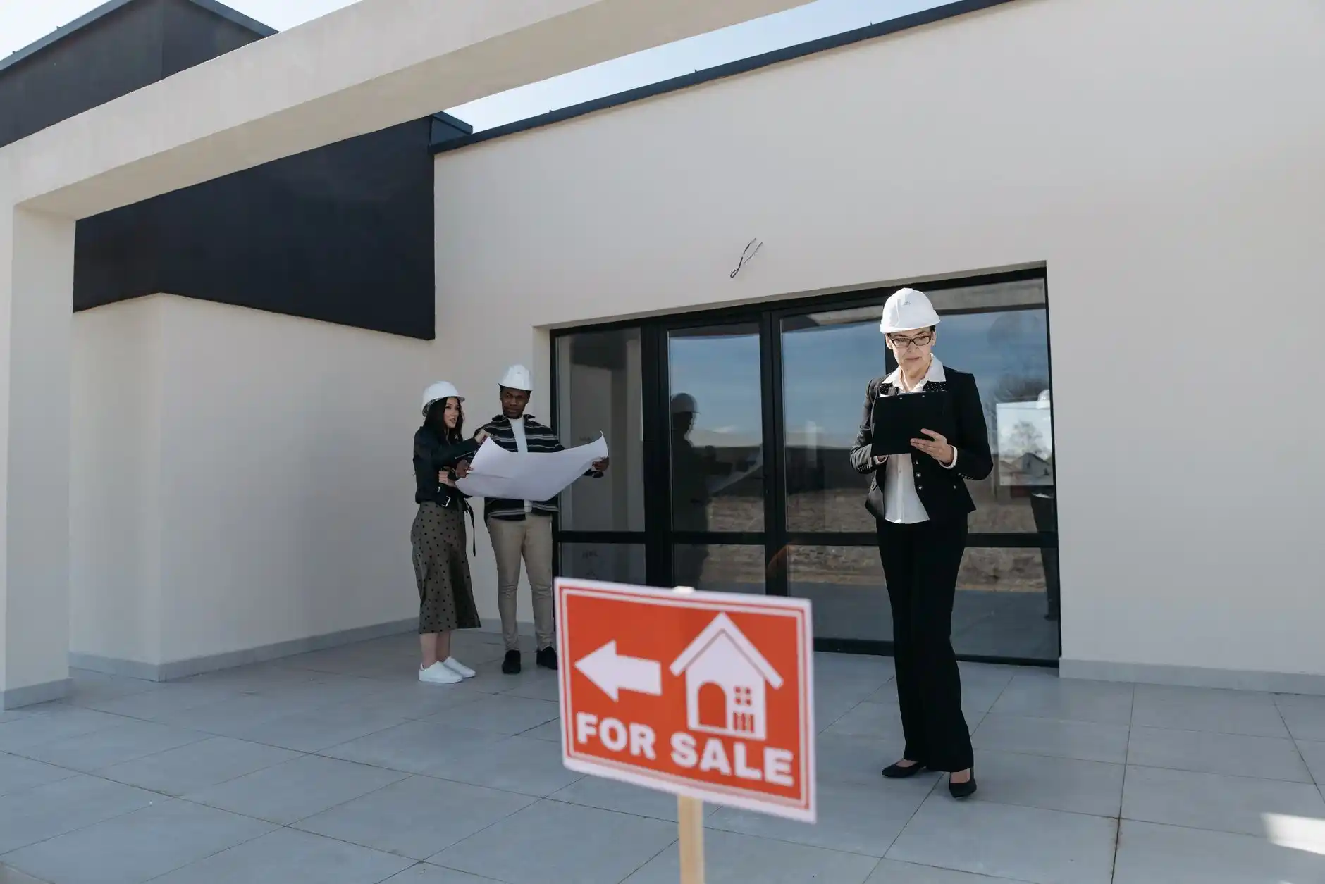 homeowner and remodeling contractor reviewing bathroom renovation plans on a tablet in a partially demolished upscale residential bathroom with exposed studs, copper plumbing, a...