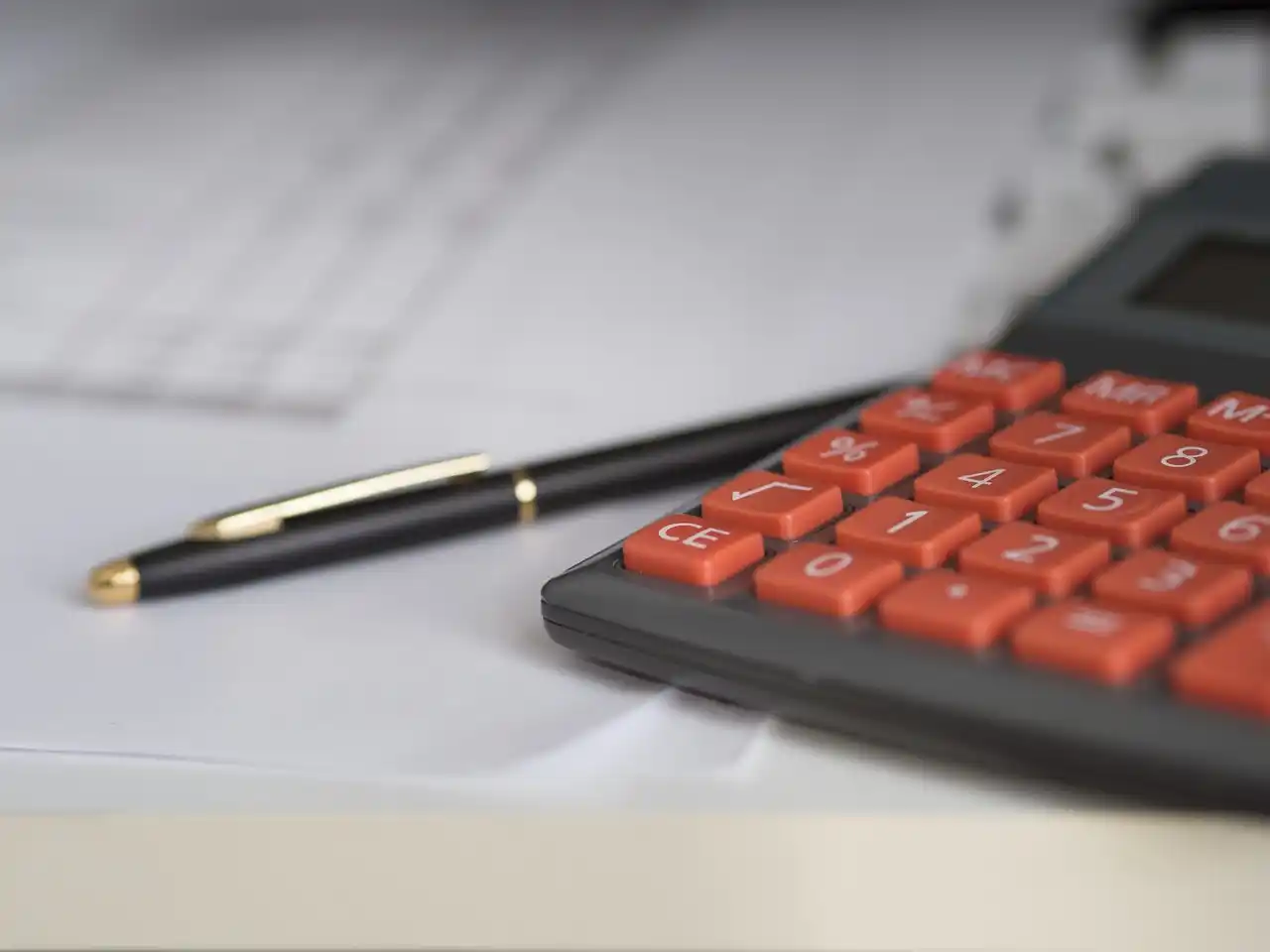 detailed overhead desk scene with architectural blueprints, draw schedule spreadsheet, calculator, stamped inspection report, and coffee beside a tablet showing home constructio...