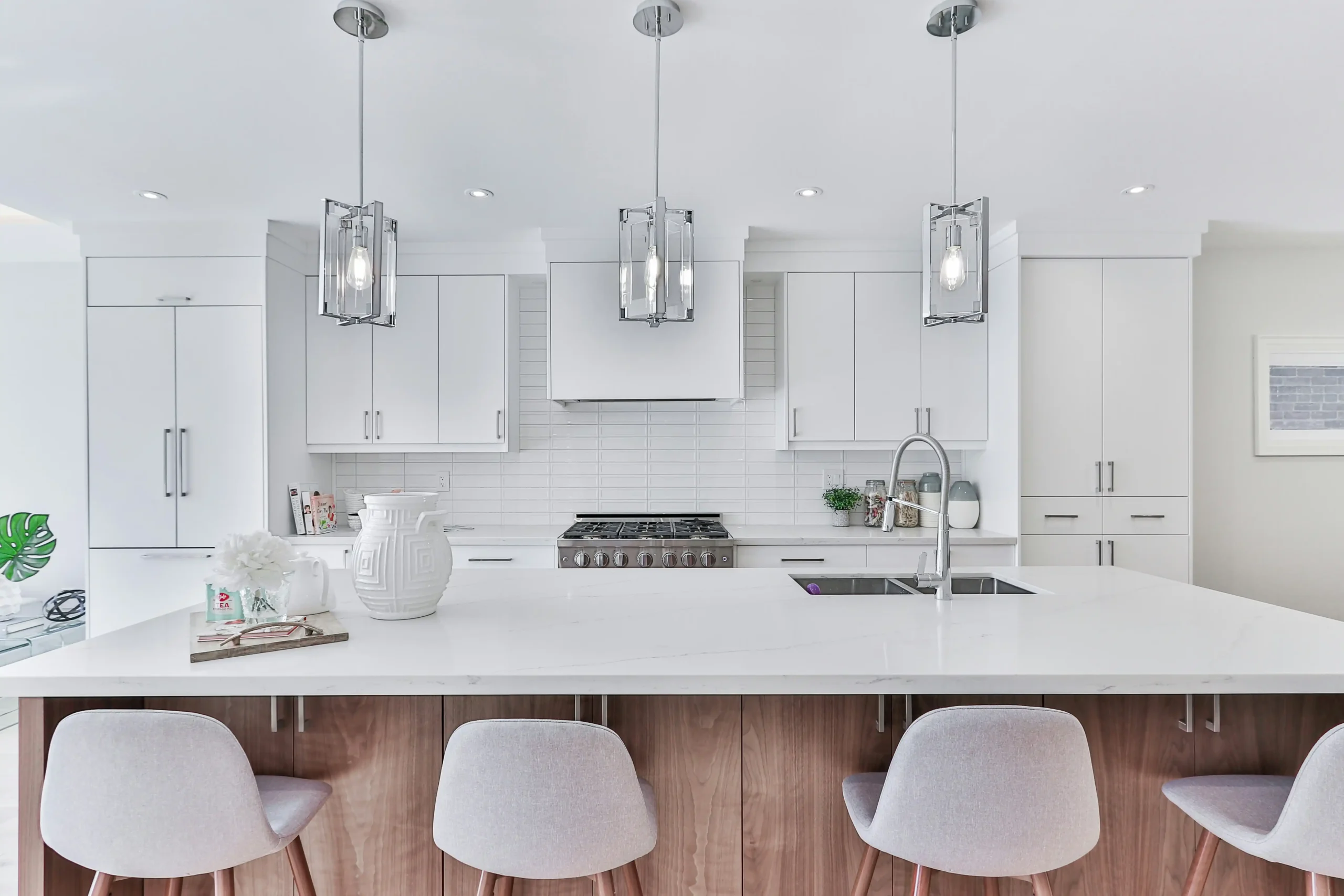 modern kitchen remodel planning meeting with homeowner reviewing finish samples, floor plans, and budget sheet beside a contractor and designer in a bright studio