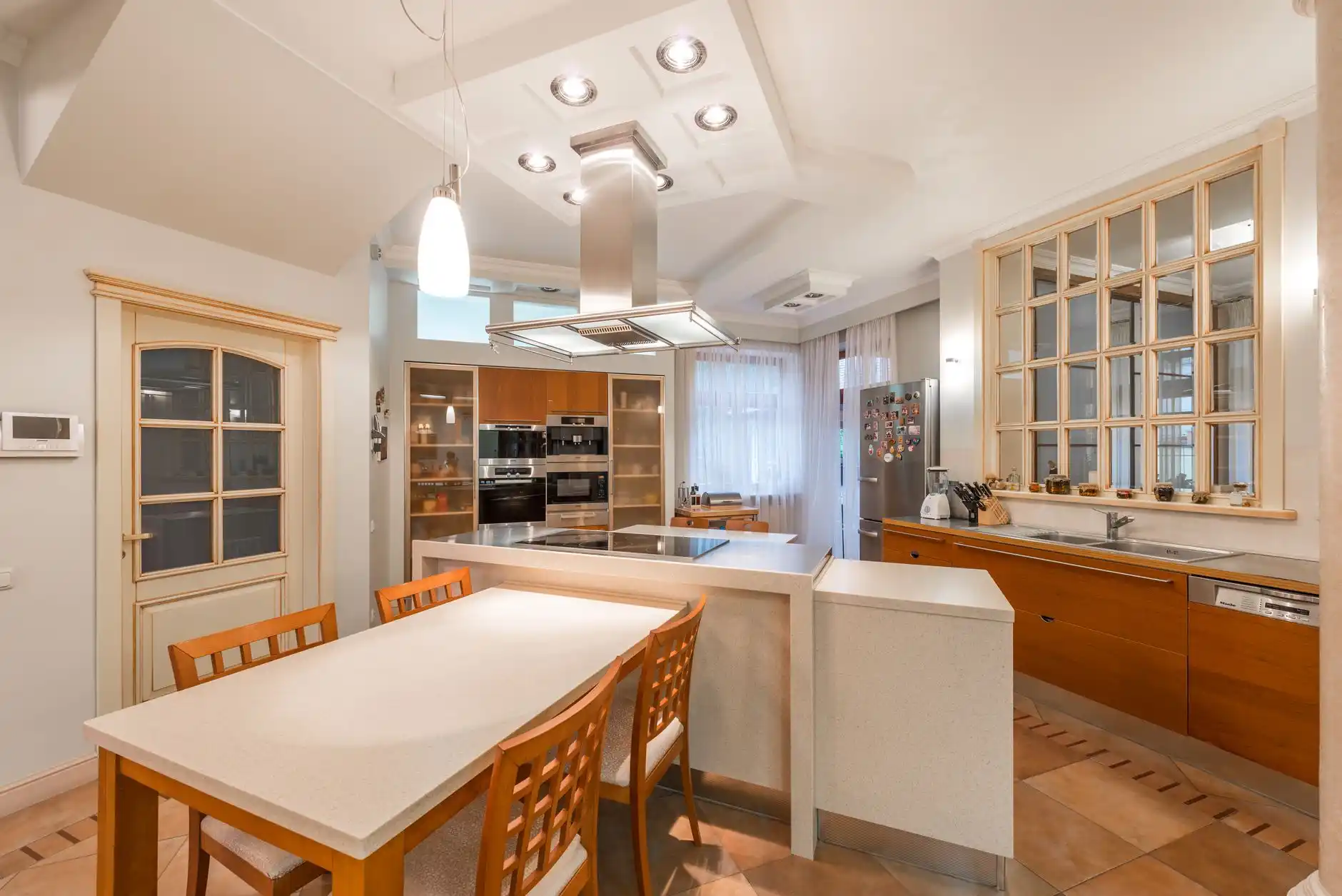 renovated older home interior with original wood staircase and trim preserved, updated open doorway to kitchen, new lighting, warm natural tones, realistic architectural photogr...