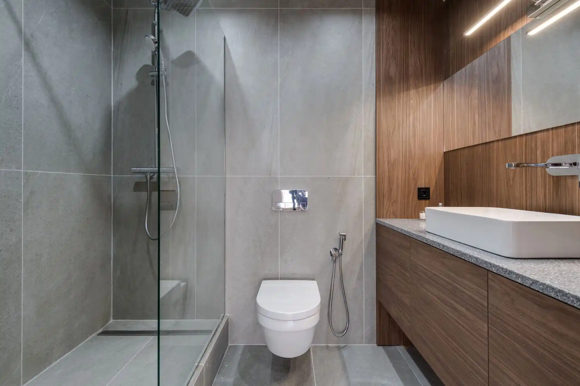 accessible bathroom with curbless walk-in shower, built-in bench, grab bars, handheld showerhead, neutral tile, realistic upscale remodel
