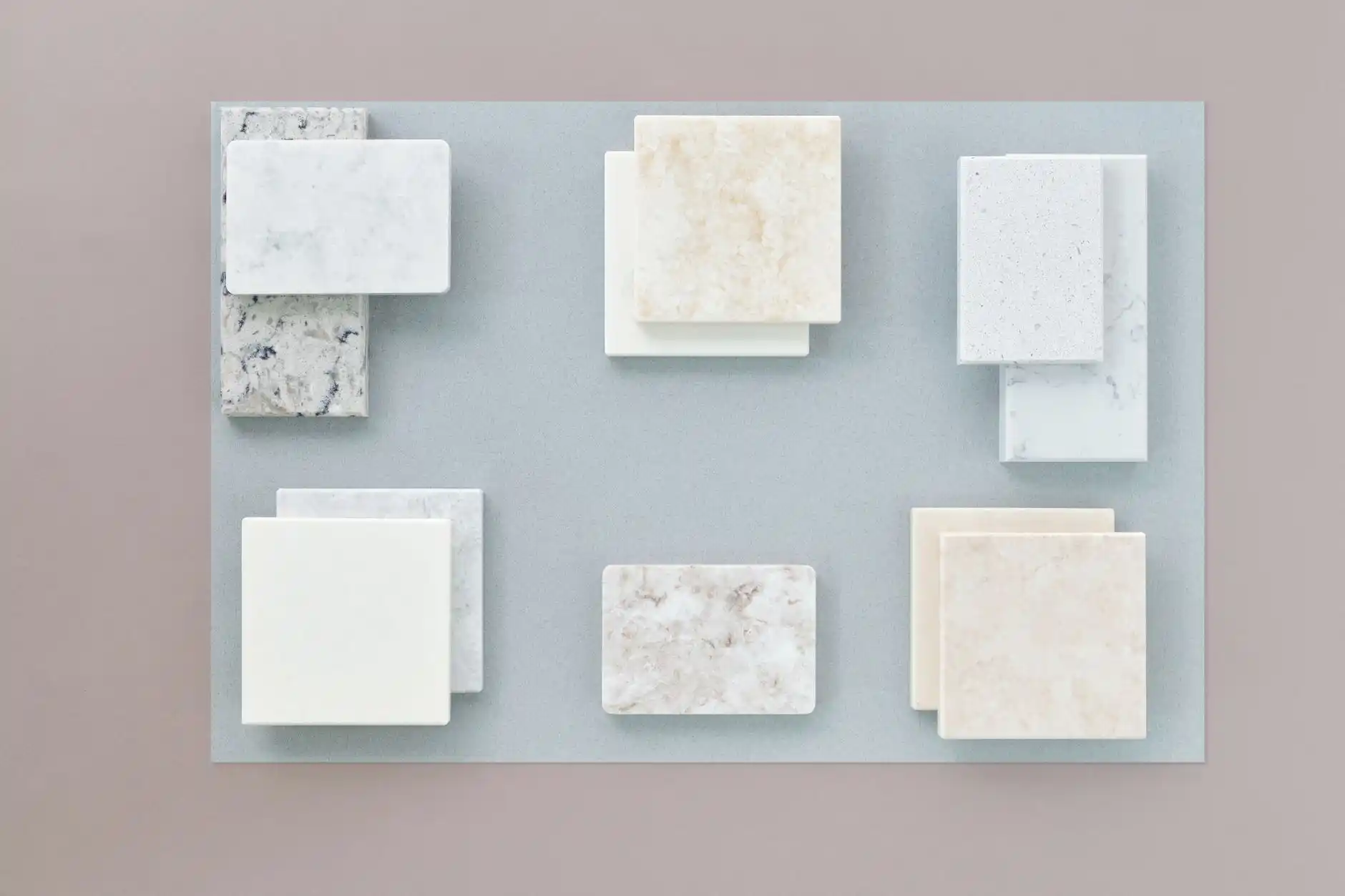 side-by-side bathroom flooring samples including matte porcelain hex tile, oak-look luxury vinyl plank, and sealed gray slate in a bright showroom setting