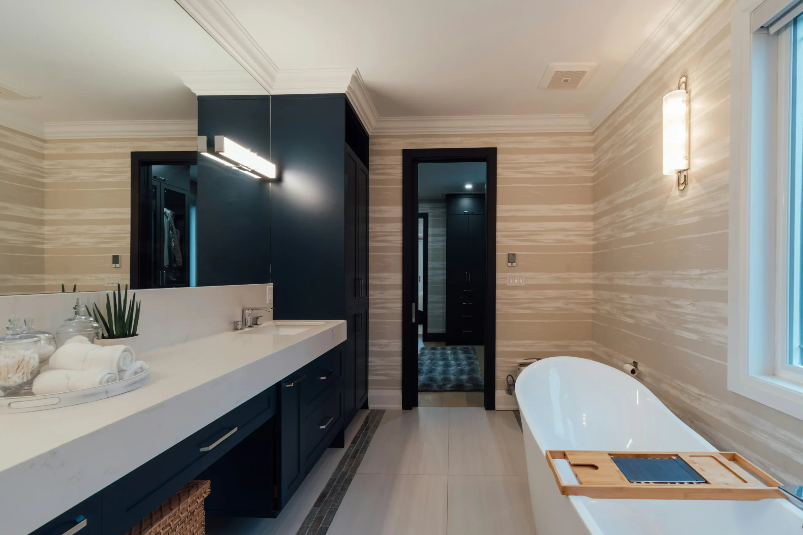 Bright contemporary Greater Seattle kitchen and bathroom renovation shown side by side, with natural wood cabinetry, quartz counters, large windows, and Pacific Northwest reside...