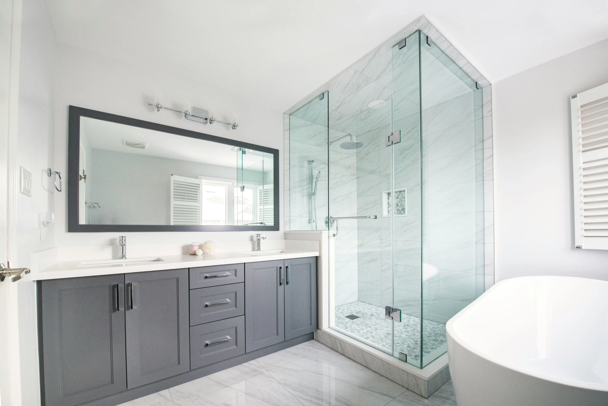 Craftsman-style Tacoma home renovation with a restored bathroom featuring hexagonal tile, inset cabinetry, period trim, modern plumbing fixtures, and warm natural light