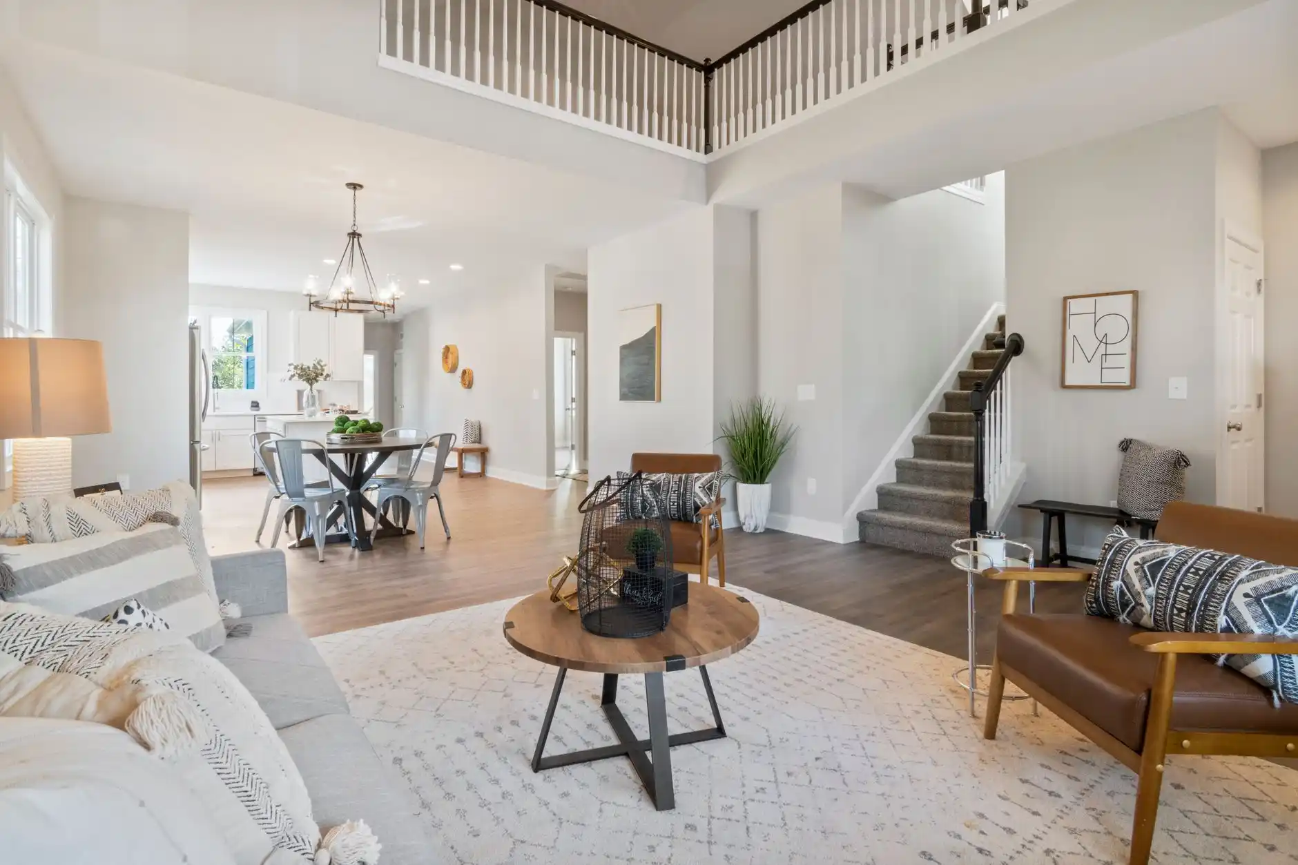 Professionally staged Seattle Craftsman living room with neutral furniture, warm lamps, large windows, restrained Pacific Northwest decor, polished wood floors, and soft daylight