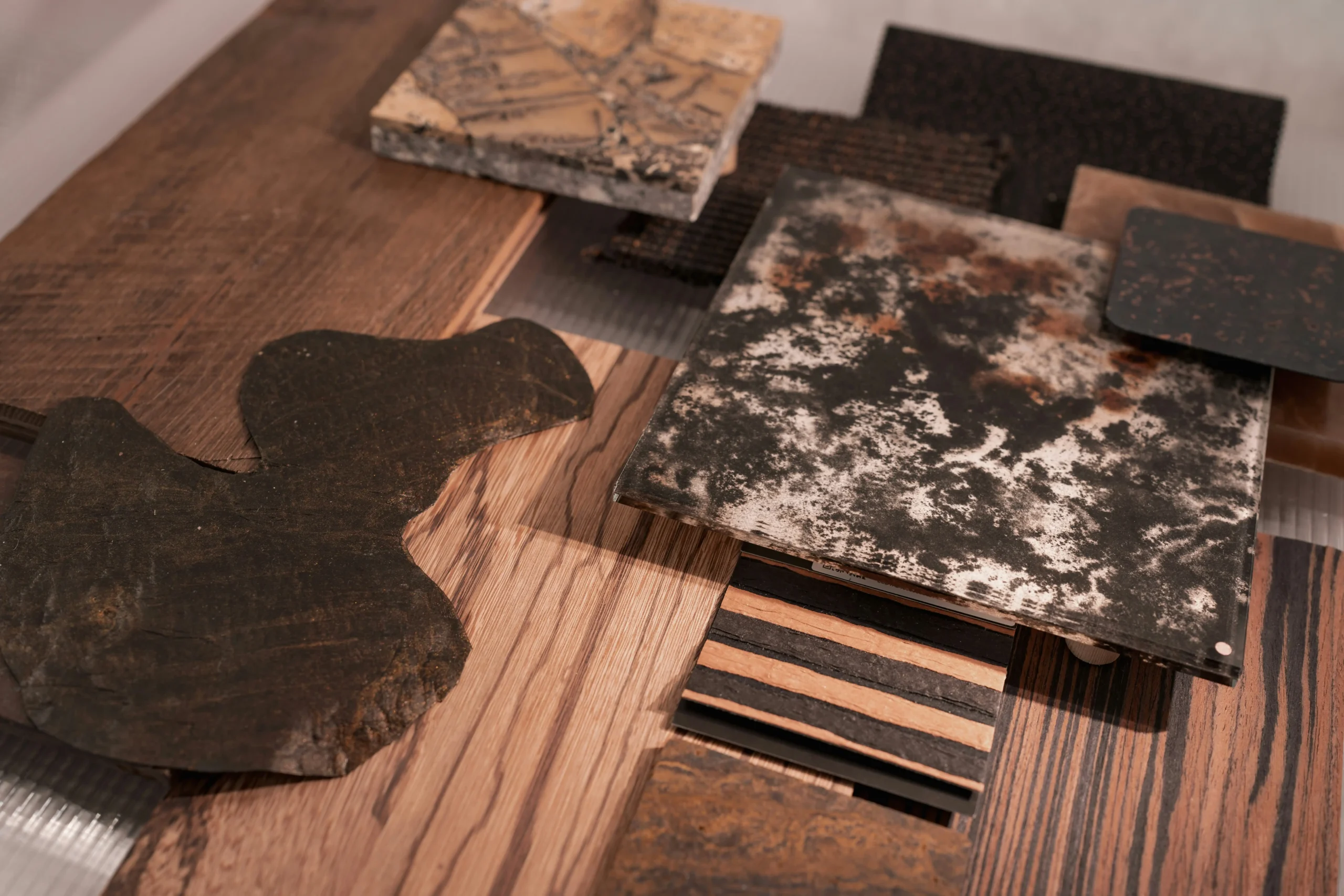 Luxury remodeling planning table with architectural drawings, itemized budget, stone and wood samples, lighting schedule, smart-home controls, and accessibility details
