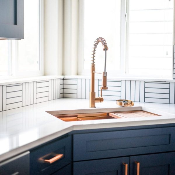 Navy kitchen with copper faucet and white countertops, United Signature remodel