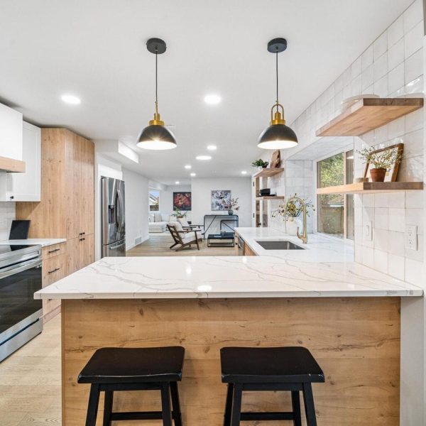 Light-wood kitchen island with brass pendants, United Signature remodel