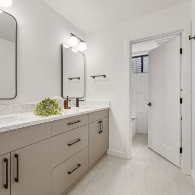 white bathroom with black and tan cabinets