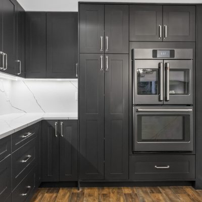 kitchen with dark black cabinets and white backsplash