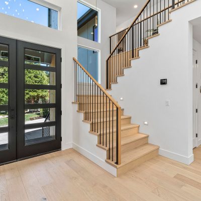 wood staircase in home with black doors